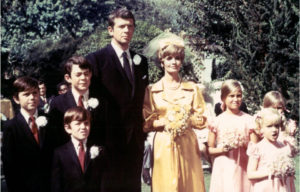 Shot of the entire Brady Bunch cast in formal clothing, the men in suits and the women in dresses.