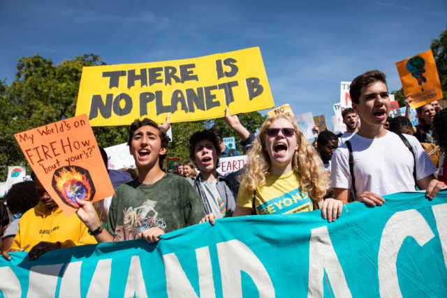 People hold signs during a climate change protest