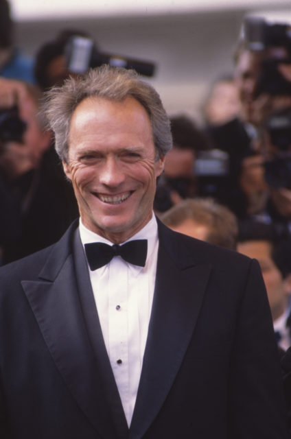 Headshot of Clint Eastwood on a red carpet in a suit with a bowtie
