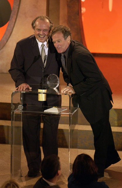 Robin Williams in a black suit with his arm around Jack Nicholson, also in a black suit.