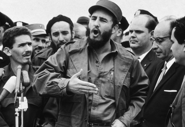 Fidel Castro speaking with men surrounding him