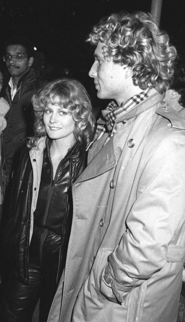 Beverly D'Angelo in a black jacket with Lorenzo Salviati in a trench coat and plaid scarf.