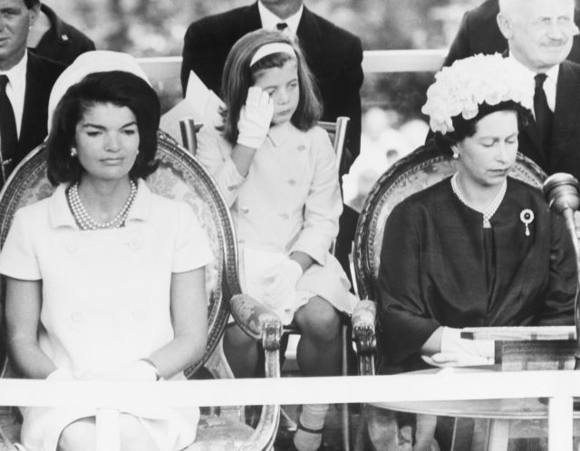 Jackie Kenney and Queen Elizabeth sitting next to each other, other people sit around them