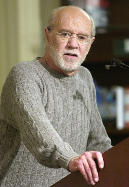 Headshot of George Carlin at a podium