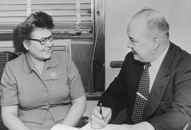 Nannie Doss laughing while she sits beside Captain Harry Stege.