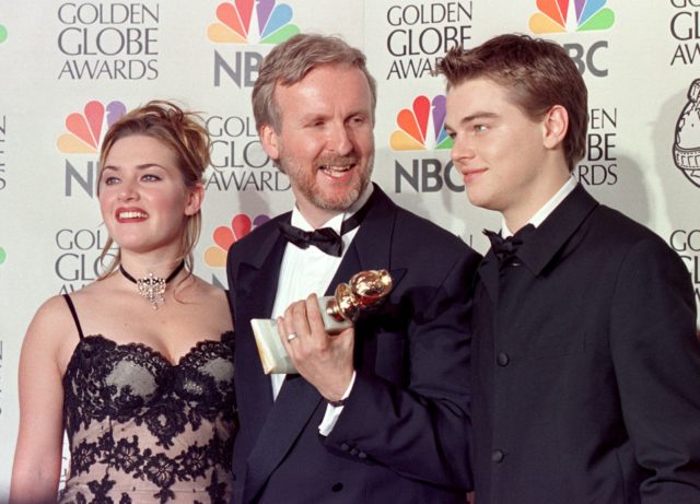 Kate Winslet, James Cameron, and Leonardo DiCaprio on a red carpet. Cameron holds an award.