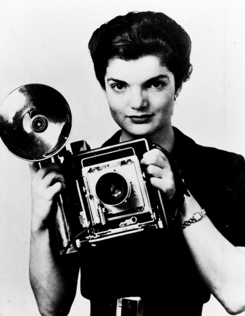 Jackie Kennedy holding a camera