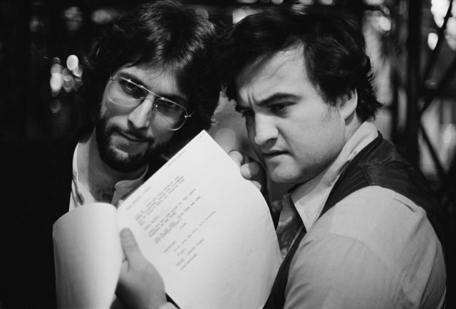John Belushi and Stephen Bishop look at a 'Saturday Night Live' script.