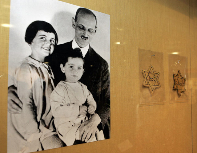 Family photo of Anne, Margot, and Otto Frank beside two yellow stars.