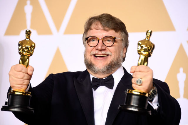 Guillermo del Toro poses with two Oscars awards