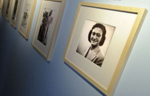 Photograph of Margot Frank hung on a blue wall.