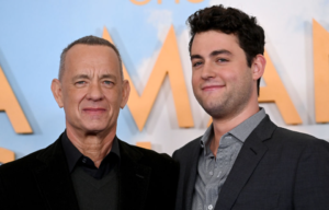 Tom and Truman Hanks, both in black jackets and collared shirts.
