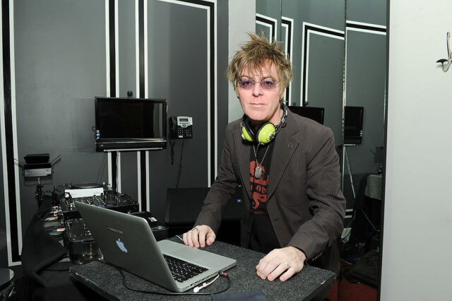 Andy Rourke standing in front of a MacBook Pro