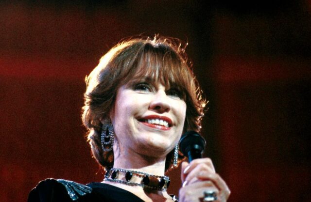 Astrud Gilberto holding a microphone on stage
