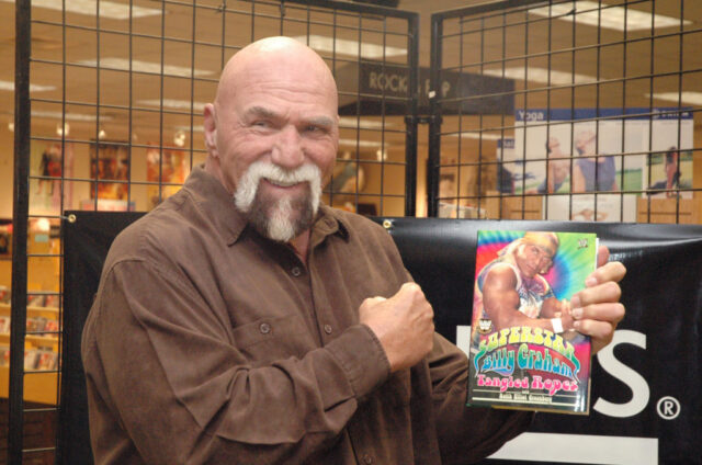 Superstar Billy Graham holding up a copy of his book