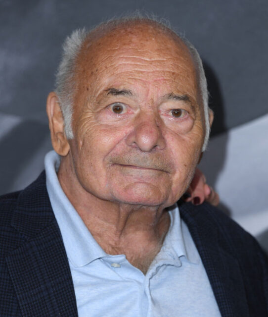 Burt Young standing on a red carpet
