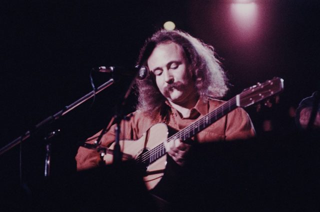 David Crosby playing the guitar on stage