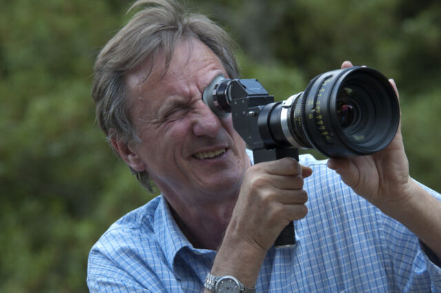 David Leland looking through a camera lens