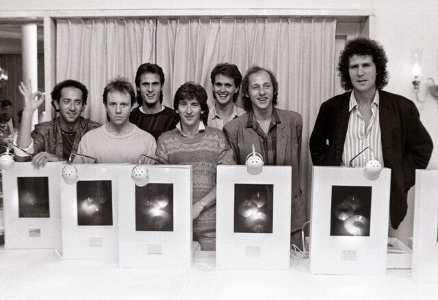 Members of Dire Straits standing together