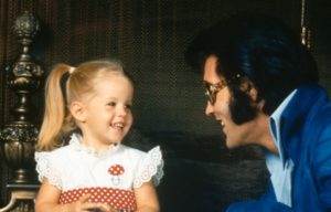 Elvis Presley smiling at Lisa Marie Presley as a young girl.