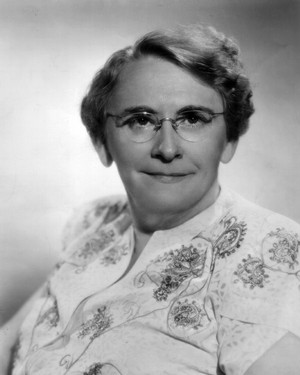Georgia Tann wearing glasses and an embroidered shirt.