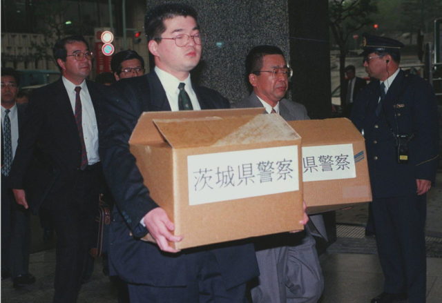Investigators with boxes of evidence from the office of Japan's leading Nuclear Power company