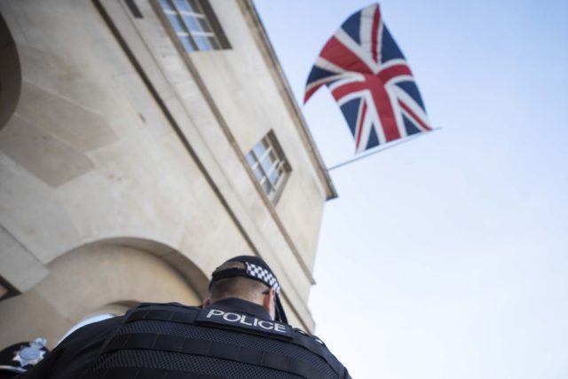 Police officer standing beneath the Union Jack