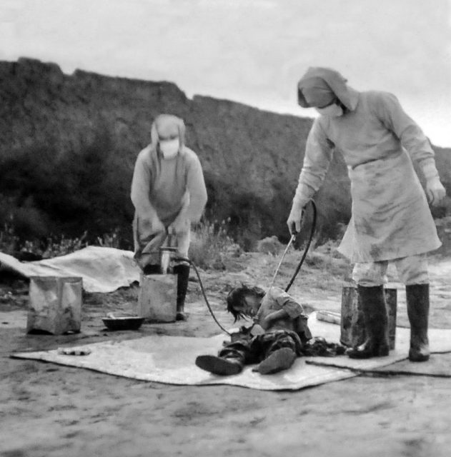 Two Japanese men spray a prisoner with a substance as part of the Unit 731 experiments