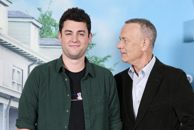 Tom Hanks looking at his son, Truman Hanks, with a blue background