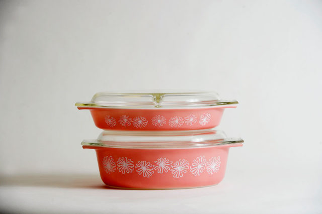 Two pink vintage Pyrex dishes stacked on each other.