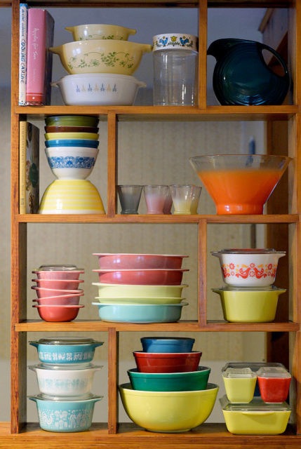 Shelves full of colored pyrex dishes.