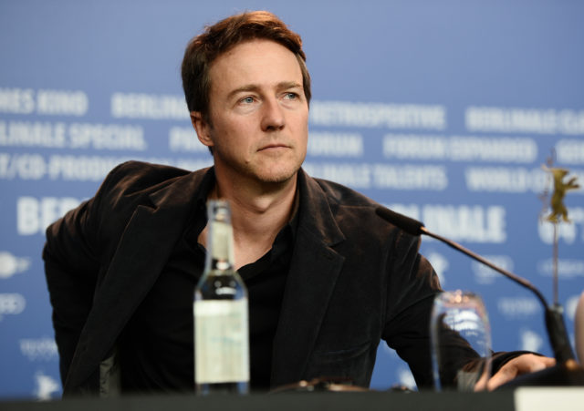 Edward Norton sitting in front of a microphone