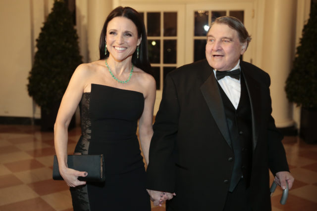 Julia Louis-Dreyfus holding hands with her father, Gérard, while both dressed up