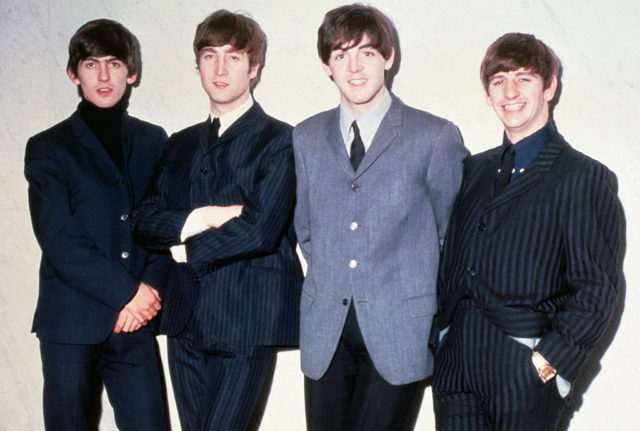 The Beatles posing together.
