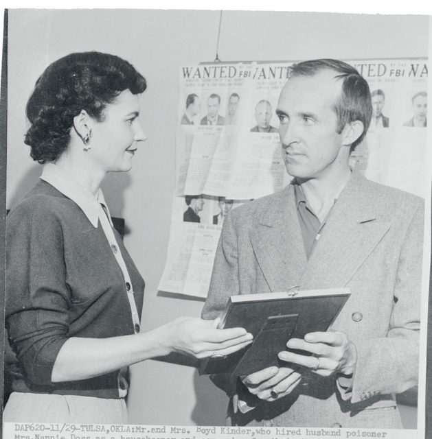 Mr. and Mrs. Boyd Kinder stand together looking at a document.