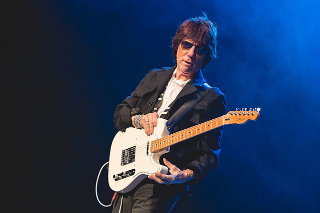Jeff Beck playing the guitar on stage