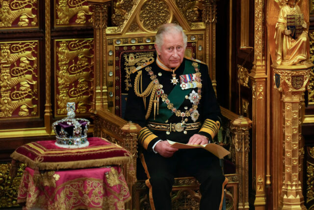 Then-Prince Charles sitting in a throne