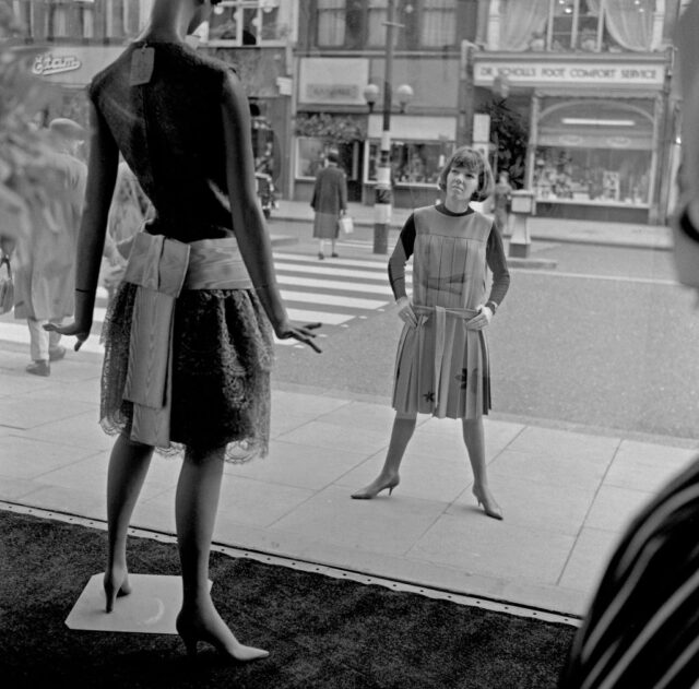 Mary Quant looking at a mannequin in a storefront window