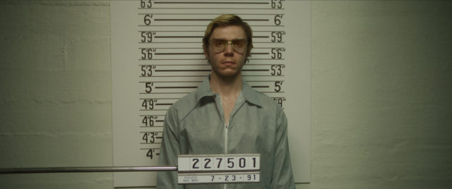 Evan Peters as Jeffrey Dahmer posing for a mug shot