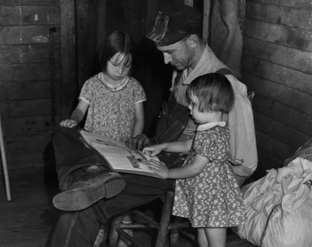 A man reading with two little girls