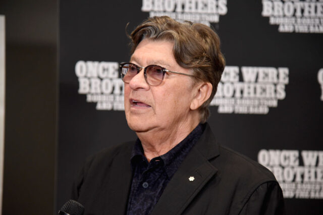 Robbie Robertson standing on a red carpet