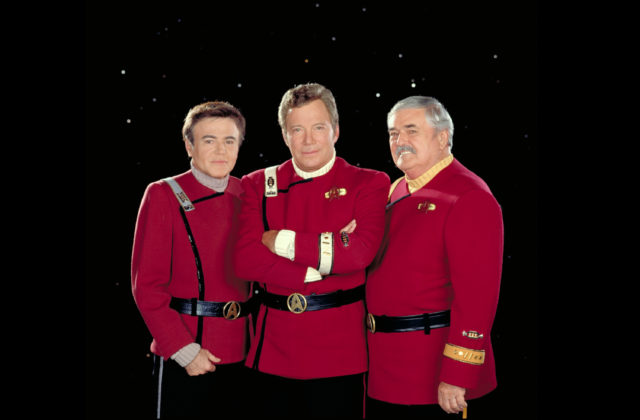 Walter Koenig, William Shatner, and James Doohan posing in their Star Trek uniforms