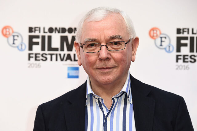 Terence Davies standing on a red carpet