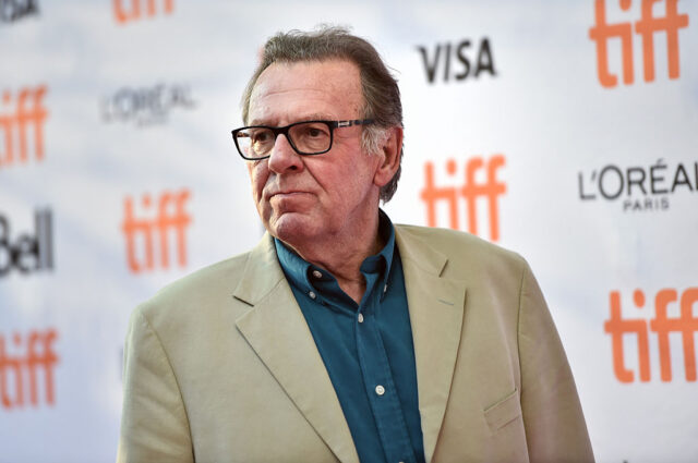 Tom Wilkinson standing on a red carpet