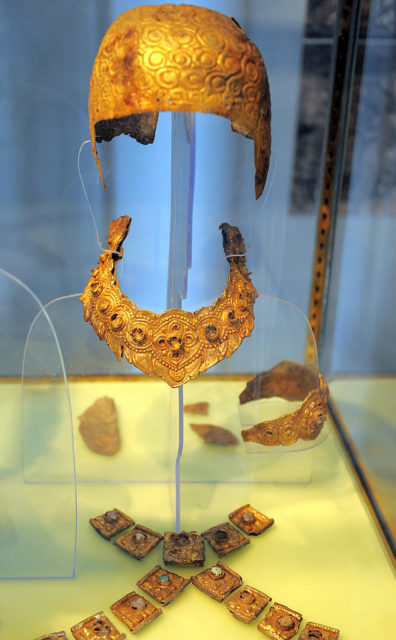 Gold crown and matching necklace on display in a museum.