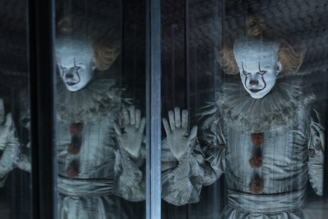 Bill Skarsgård as Pennywise the clown reflected side by side in a mirror.