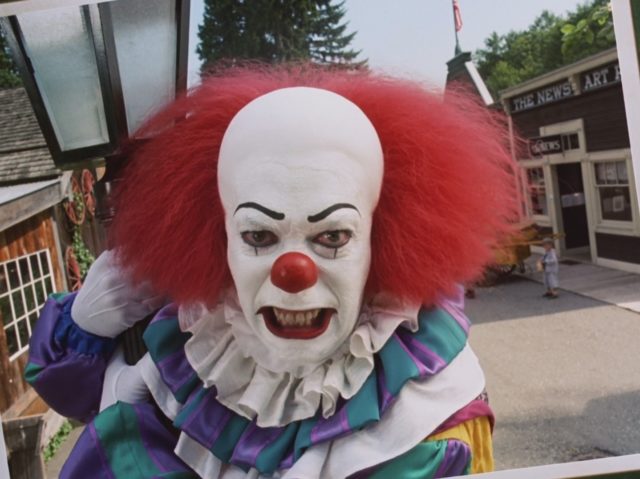 Tim Curry as Pennywise the Dancing Clown growling at the camera.