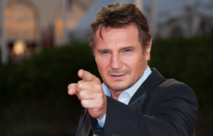 Shot of Liam Neeson pointing at a photographer