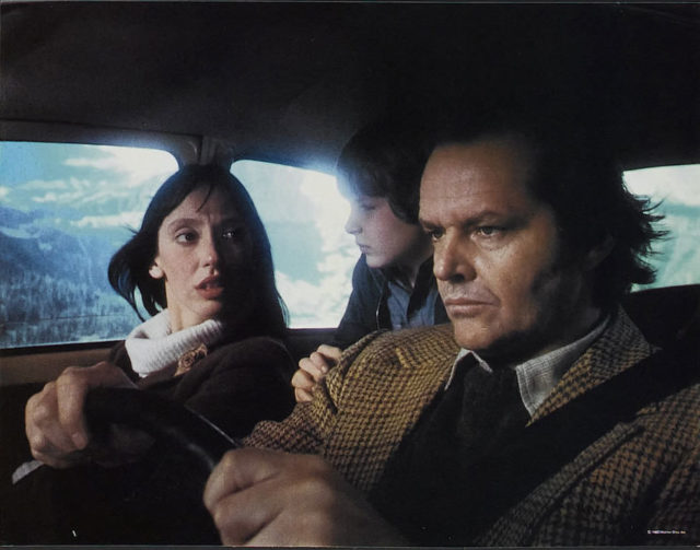 Jack Nicholson, Shelley Duvall, and Danny Lloyd in a car in one of the opening scenes of The Shining. 