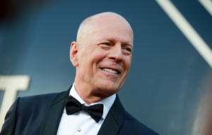Headshot of Bruce Willis looking and smiling to his left.